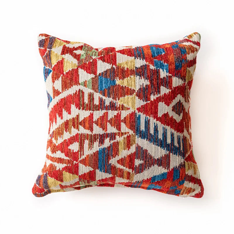 Multicolored geometric patterned pillow on a white background. Bohemian Aztec woven pillow cover, geometric jacquard cushion for sofa, bed, or living room decor in neutral cotton blend fabric.