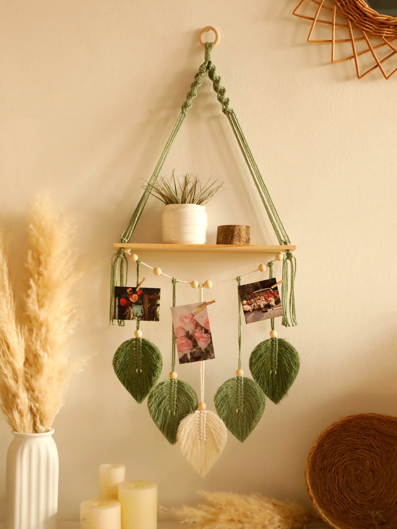 Hanging plant holder with wooden shelf, plants, and decorative elements against a beige wall.