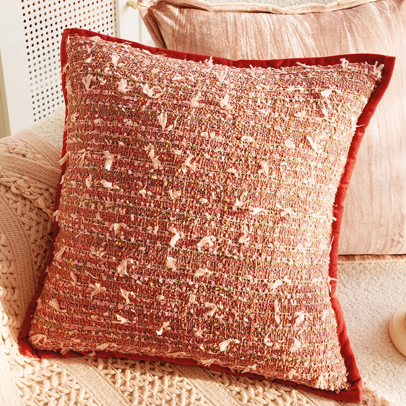Textured red pillow on a couch with a neutral background. Boho Home Decor.