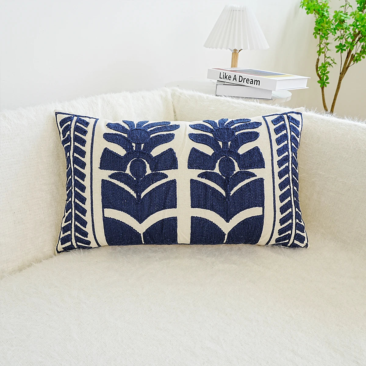 Lumbar cushion cover with blue geometric patterns on a white background, placed on a neutral fabric surface.