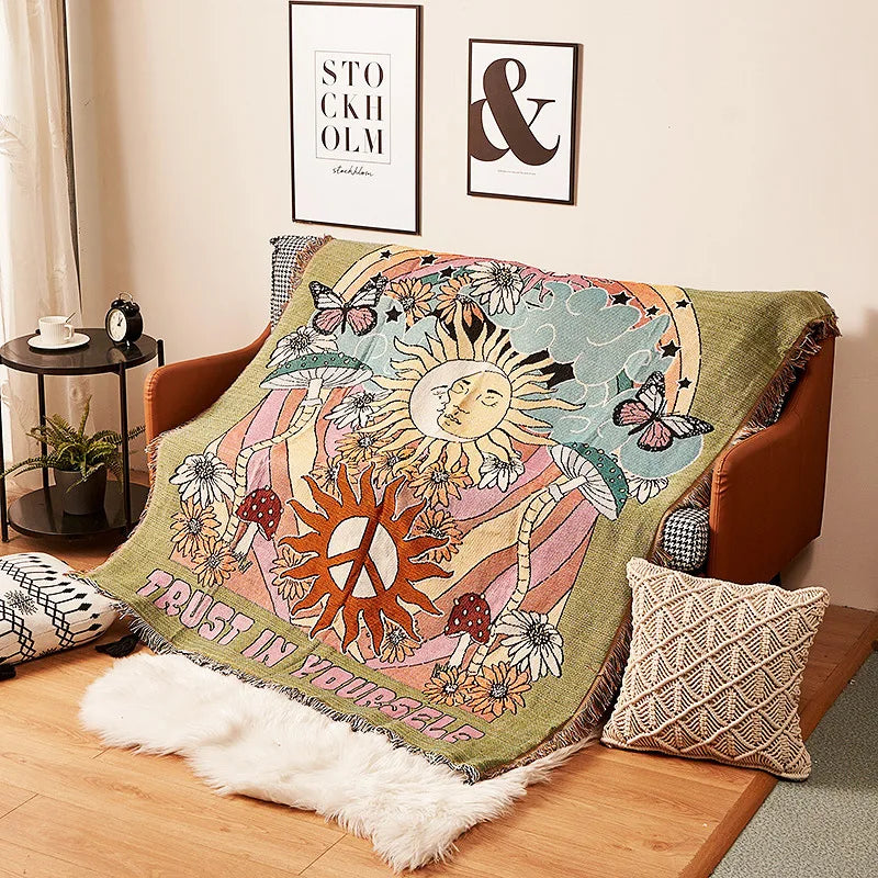 Decorative blanket with sun and moon design on a couch in a living room. Boho Home Decor.