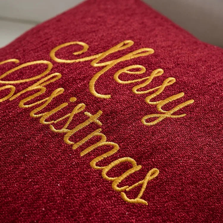 Red fabric with 'Merry Christmas' embroidered in gold thread