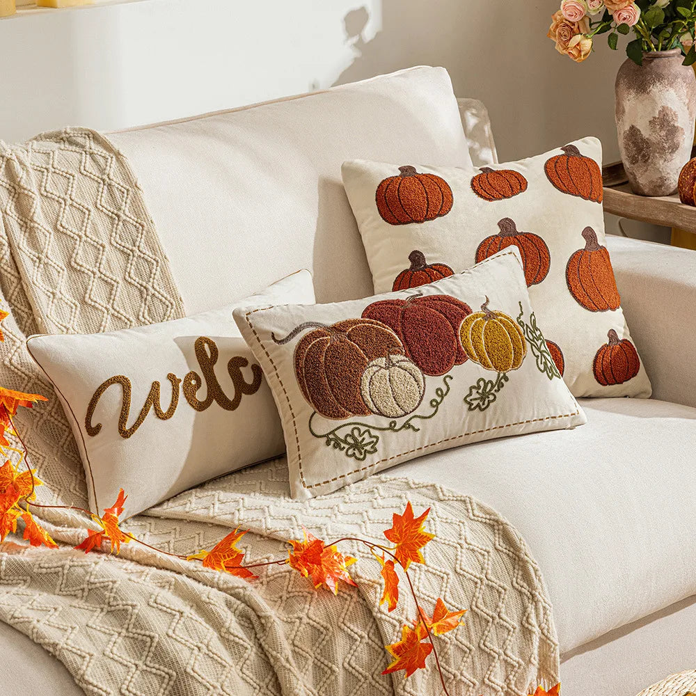Decorative pillows with pumpkin patterns and a 'welcome' pillow on a couch. Autumn velvet embroidered pumpkin pillow cover, Nordic-style decorative cushion for sofa, bed, and fall boho home decor