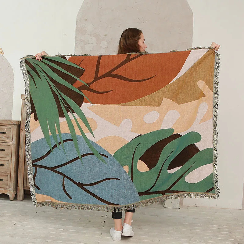 Person holding a large decorative blanket with leaf patterns in a room. Boho Home Decor.