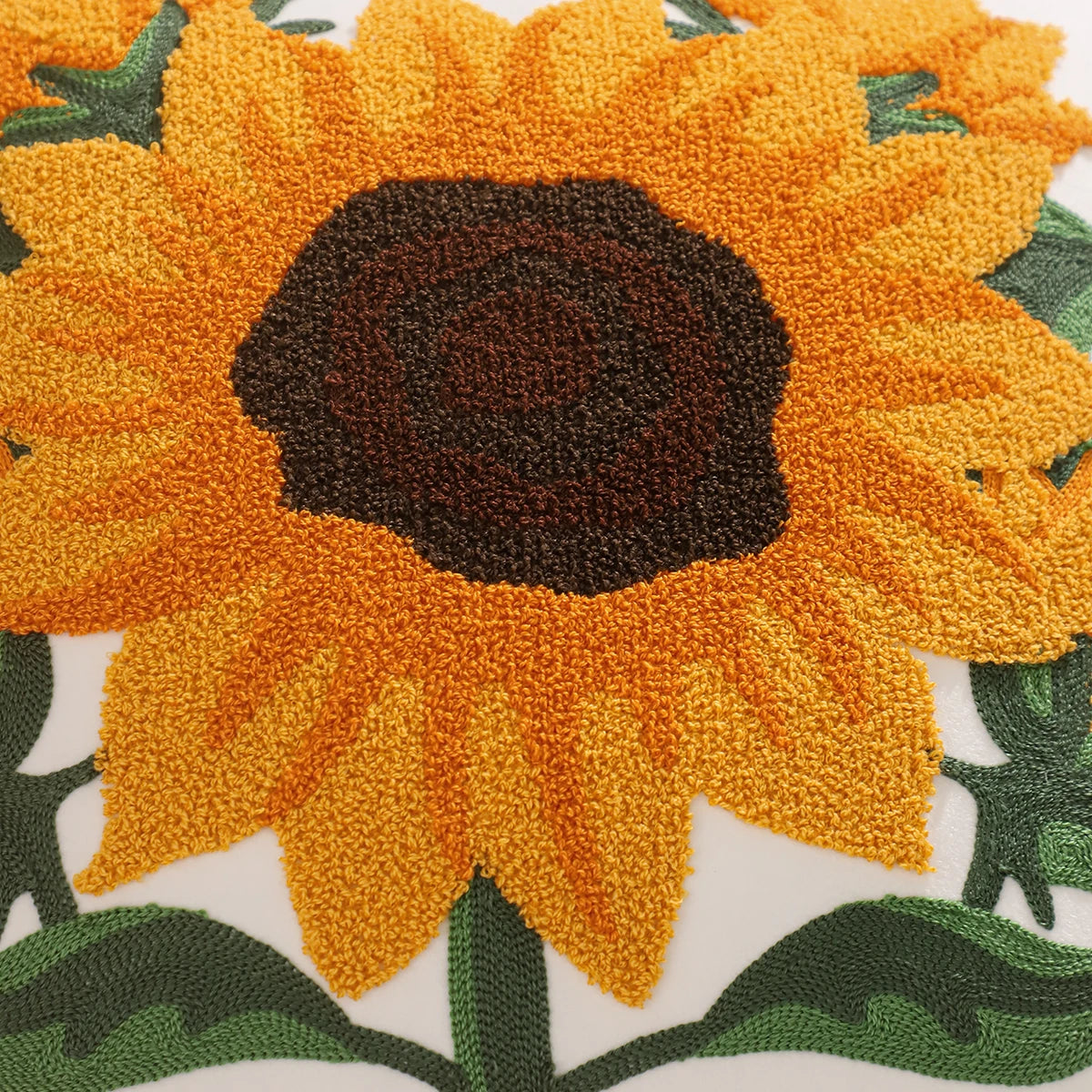 Embroidered sunflower design on fabric with green leaves. Velvet pillow cover with embroidered pumpkins, sunflowers, and autumn leaves – cozy fall home décor for sofa or living room.