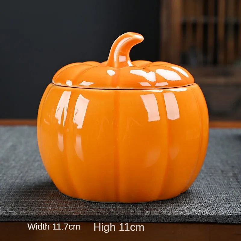 Orange ceramic pumpkin-shaped container on a dark surface. Ceramic pumpkin candy jar with lid, decorative fall tea jar or wedding gift container for home or halloween holiday decor.