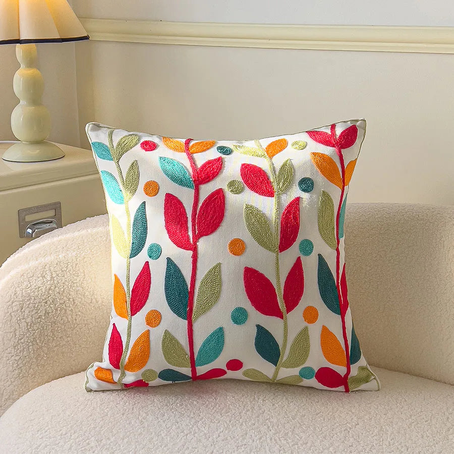 Decorative pillow with colorful leaf pattern on a beige sofa