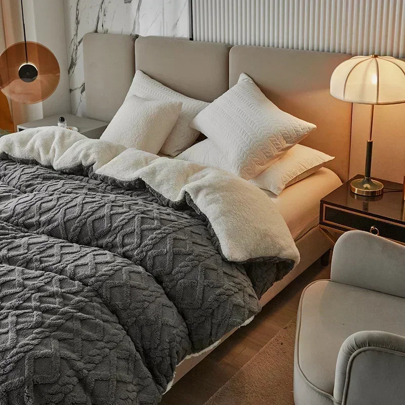 Neatly made bed with gray comforter and white pillows in a bedroom setting. Soft plush duvet cover and blanket in solid color with striped jacquard design, dual-use artificial cashmere fleece bedding for cozy winter warmth