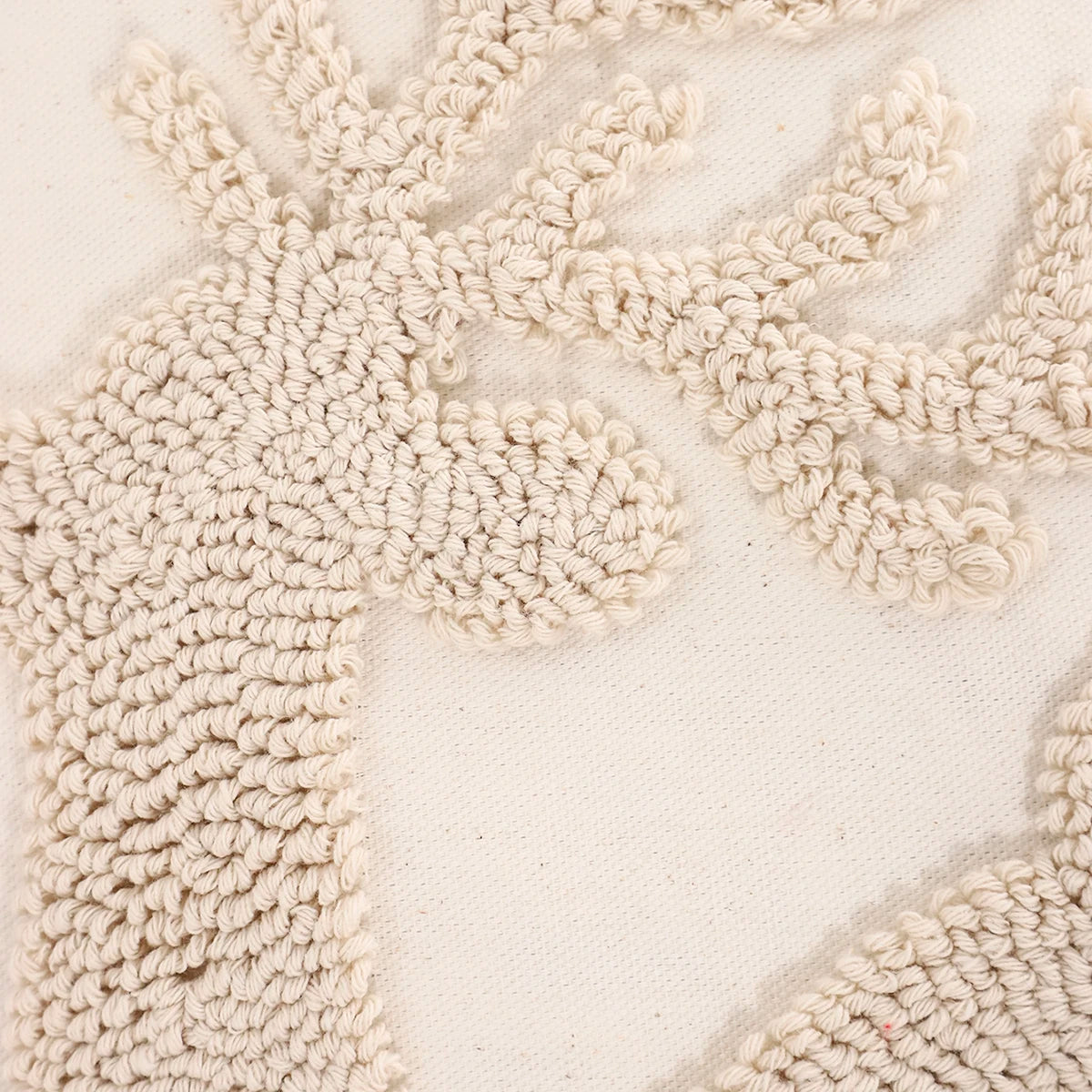Close-up of a textured beige rug with a subtle pattern. Christmas embroidered pillow cover with tufted snowflake and reindeer design in 18x18 inches, festive canvas cushion case for sofa or bed