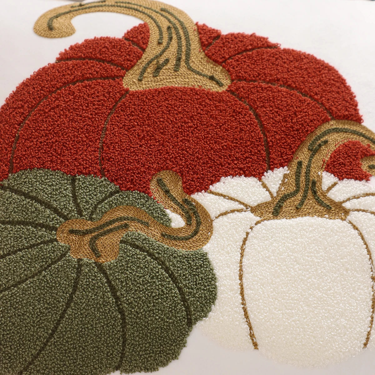 Decorative rug with red, green, and white pumpkins on a white background. Velvet pillow cover with embroidered pumpkins, sunflowers, and autumn leaves – cozy fall home décor for sofa or living room.