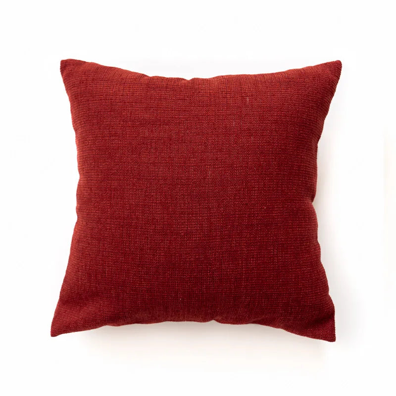 Red pillow on a white background. Bohemian Aztec woven pillow cover, geometric jacquard cushion for sofa, bed, or living room decor in neutral cotton blend fabric.