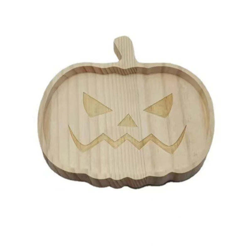 Wooden pumpkin-shaped cutting board with a carved face on a white background. Wooden Halloween serving tray in pumpkin and ghost shapes, rustic snack and dessert plate for party décor and fall entertaining