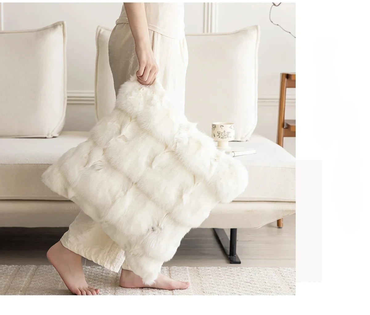 Person holding a fluffy white pillow in a living room setting. embroidery throw pillow cover in boho modern style