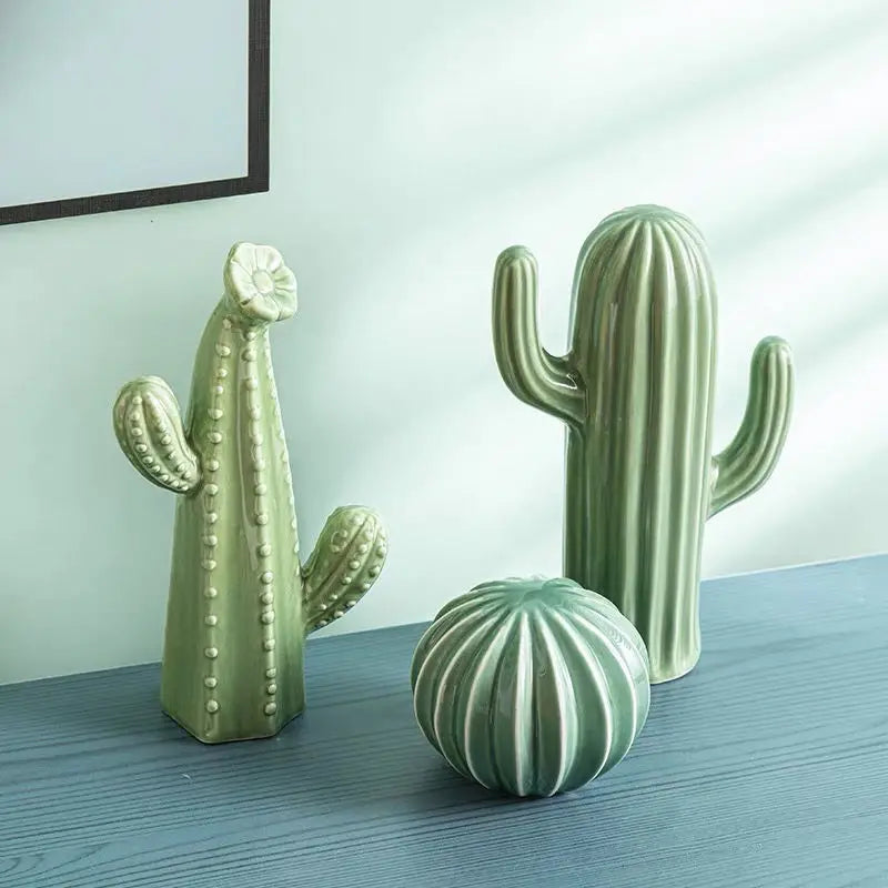 Three green cactus-shaped decorative items on a wooden surface with a light blue wall in the background. Modern ceramic cactus figurine for home or office decoration. House warming gift.
