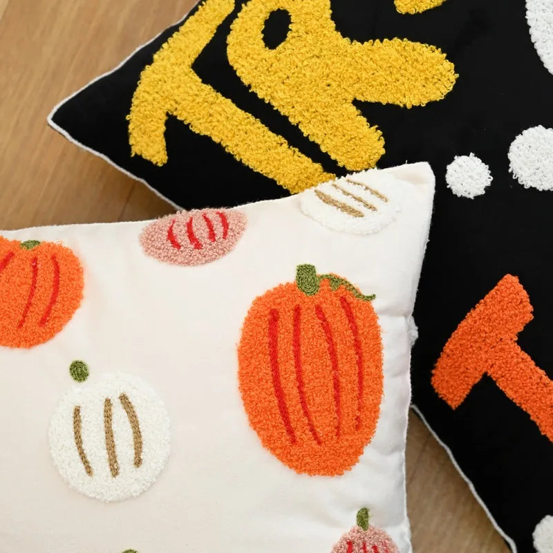Decorative pillows with pumpkin patterns on a wooden surface