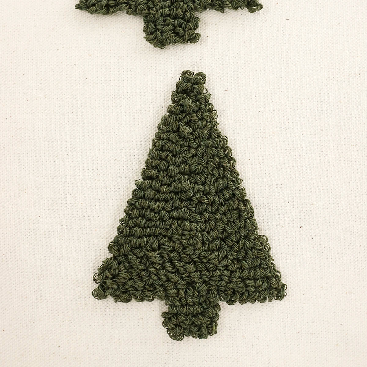 Green knitted tree-shaped ornament on a white background. Christmas Boho Home Decor embroidered pillow cover with tufted snowflake and reindeer design in 18x18 inches, festive canvas cushion case for sofa or bed