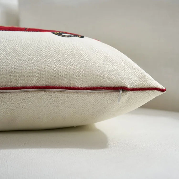Close-up of a white pillow with red stitching on a neutral background