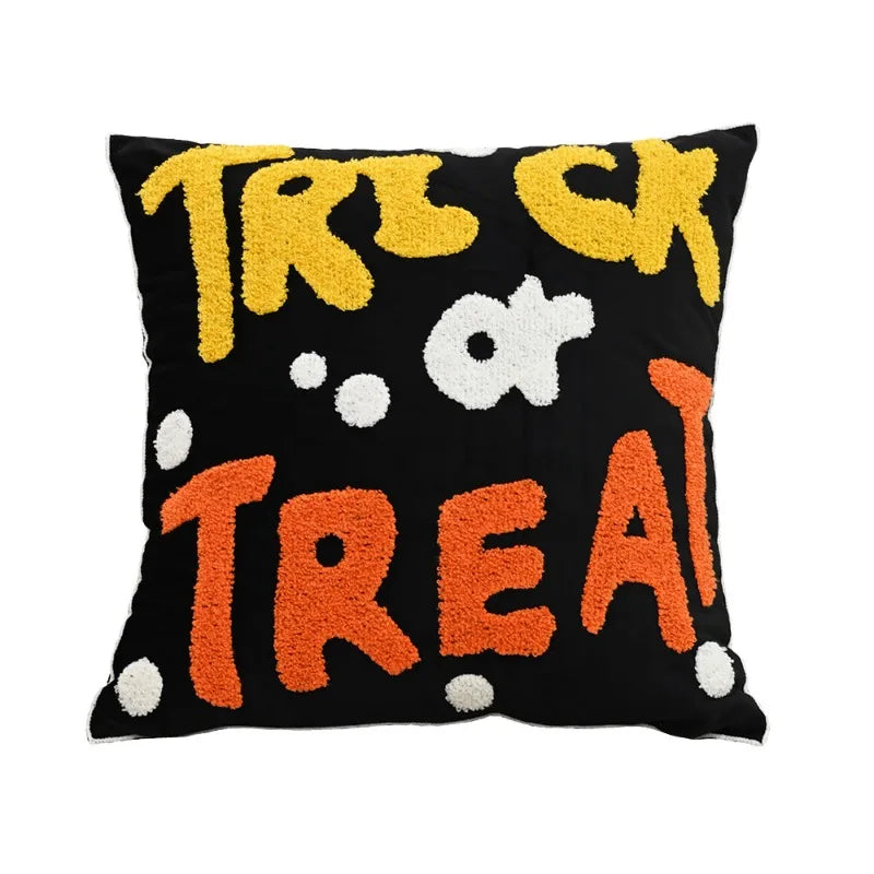 Decorative pillow with 'Trick or Treat' text in yellow, orange, and white on a black background.