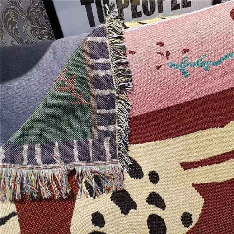 Collection of patterned rugs with various designs on a textured surface. Animal print bohemian throw blanket with leopards, woven cotton polyester tapestry blanket