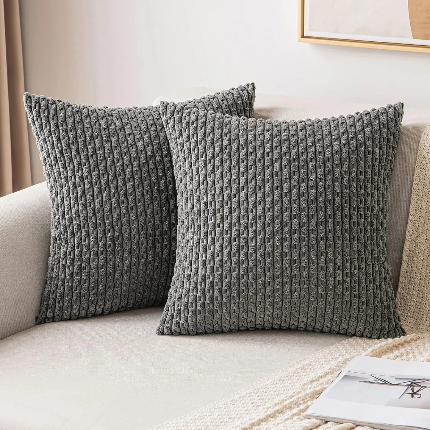 Two textured gray pillows on a beige sofa.