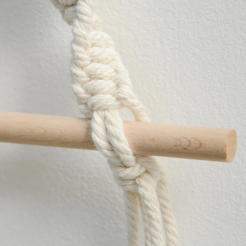 Close-up of a wooden stick with a knotted white rope on a light gray background boho home decor, toilet paper holder, bohemian bathroom accessory, tissue holder, wall-mounted towel rack, cotton rope toilet paper rack, wooden bead towel holder, rustic home decor, boho wall decor, bathroom organization, housewarming gift