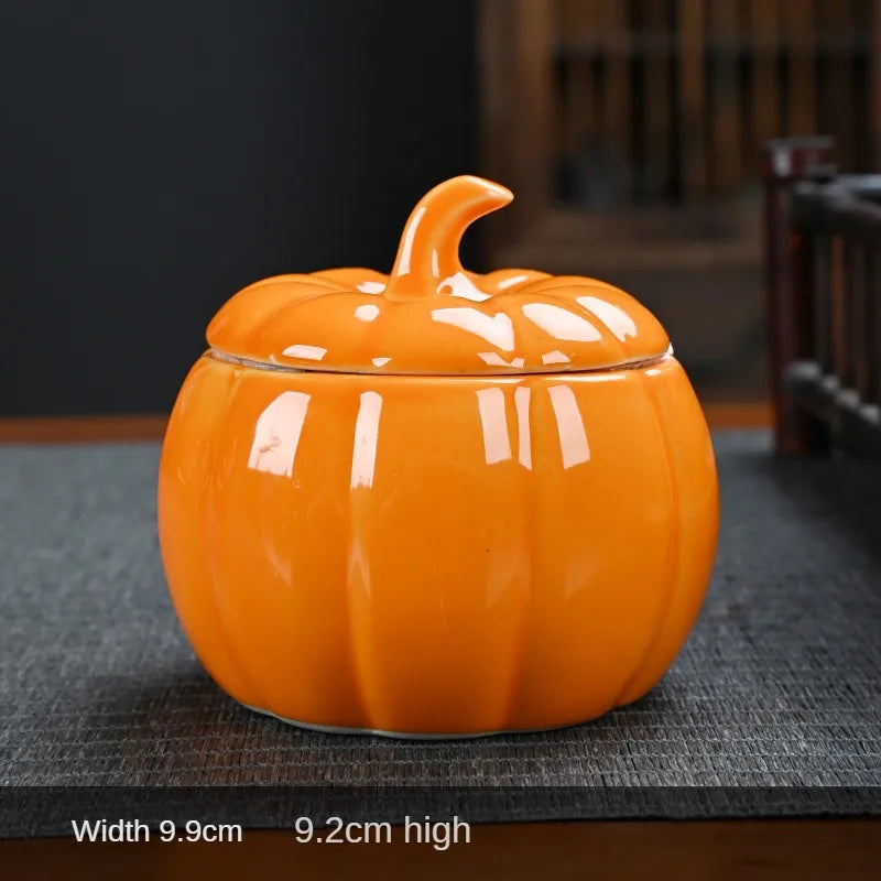 Orange ceramic pumpkin-shaped container on a dark surface. Ceramic pumpkin candy jar with lid, decorative fall tea jar or wedding gift container for home or halloween holiday decor.