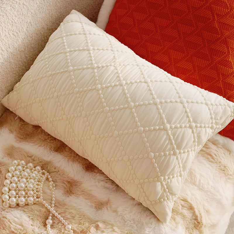 Quilted white pillow on a textured surface with a red fabric background. Boho Home Decor.