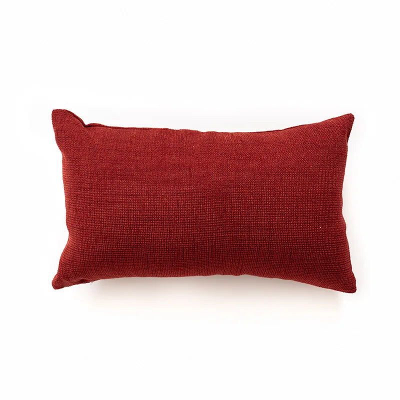 Red textured pillow on a white background. Bohemian Aztec woven pillow cover, geometric jacquard cushion for sofa, bed, or living room decor in neutral cotton blend fabric.