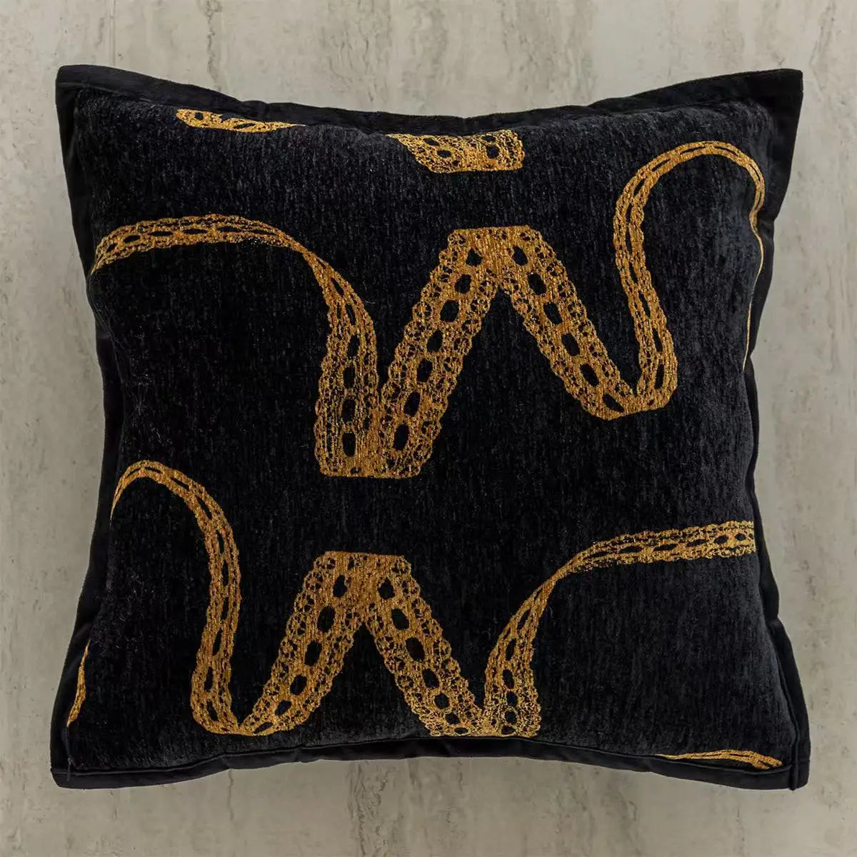 Black pillow with gold embroidered patterns on a textured surface. embroidery throw pillow cover in boho modern style