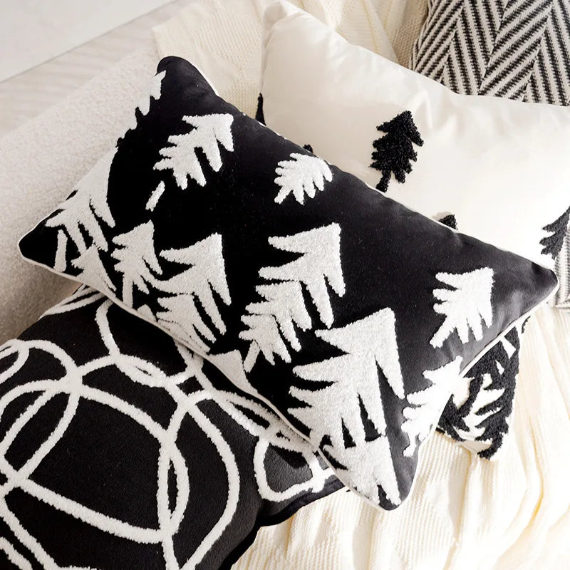Black and white Christmas tree patterned pillows on a sofa