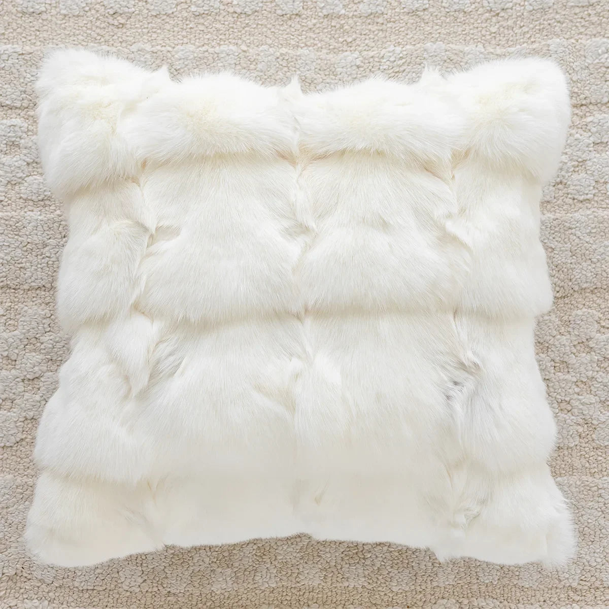 White fur rug on a beige carpet. embroidery throw pillow cover in boho modern style