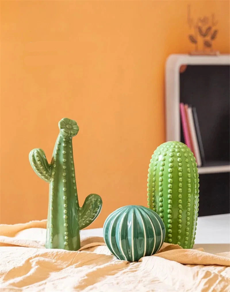 Decorative cacti on a surface with an orange wall in the background. Boho Nordic cactus decor prop for photography and interiors
