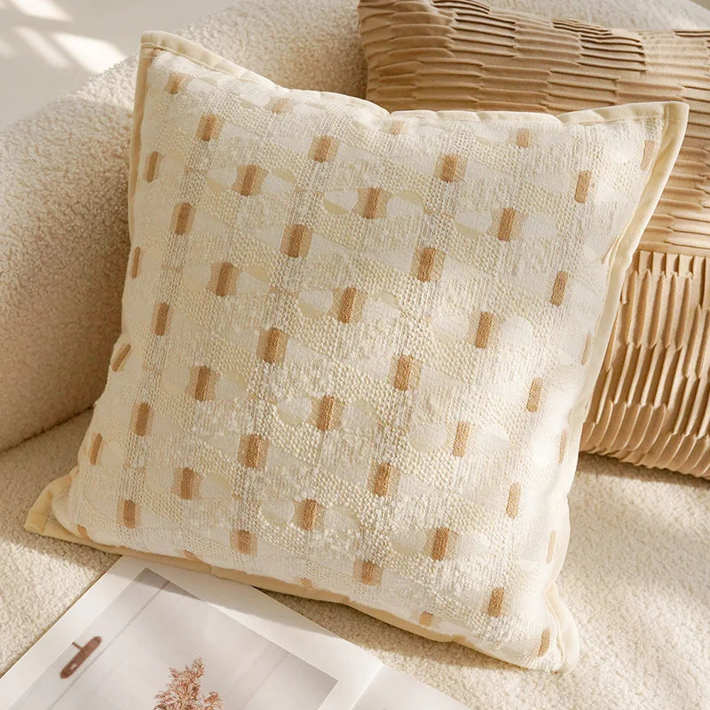 Beige pillow with a subtle pattern on a beige sofa