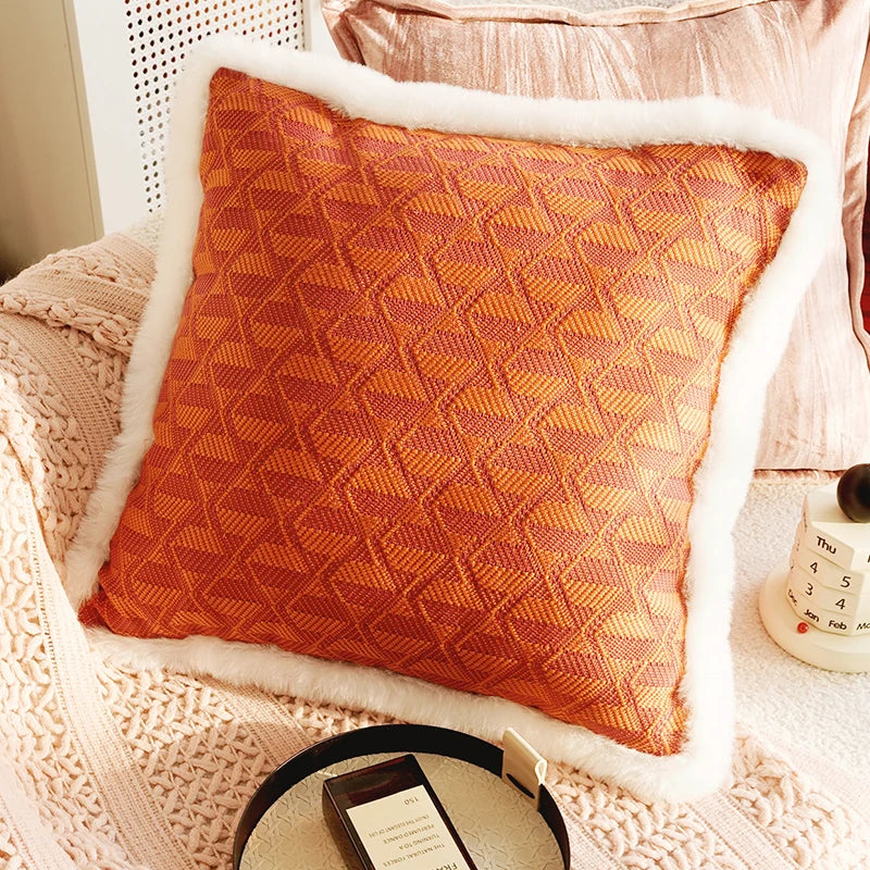 Orange textured pillow on a white chair with a pink blanket. Boho Home Decor.