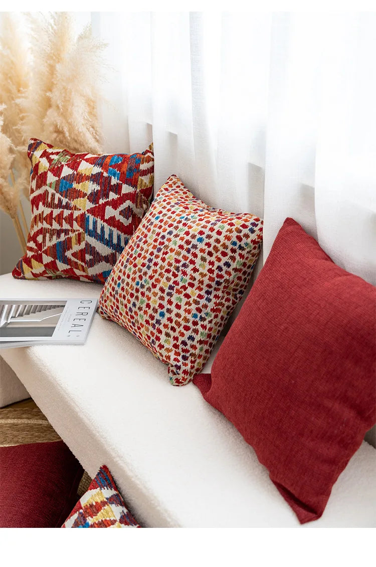 Decorative pillows on a white bench with a neutral background. Bohemian Aztec woven pillow cover, geometric jacquard cushion for sofa, bed, or living room decor in neutral cotton blend fabric.