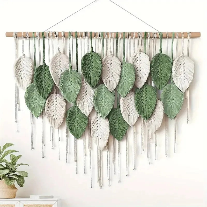 Wall hanging with leaf-shaped decorations on a white wall.