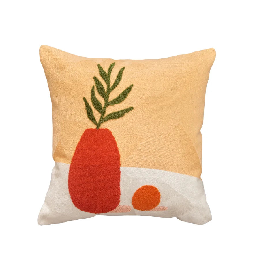 Decorative pillow with a red vase and green leaves on a beige background