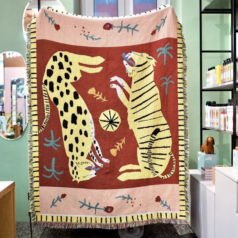 Decorative blanket with a cheetah and tiger design in a room setting. Leopard design boho home decor blanket, decorative woven tapestry for living room or bedroom