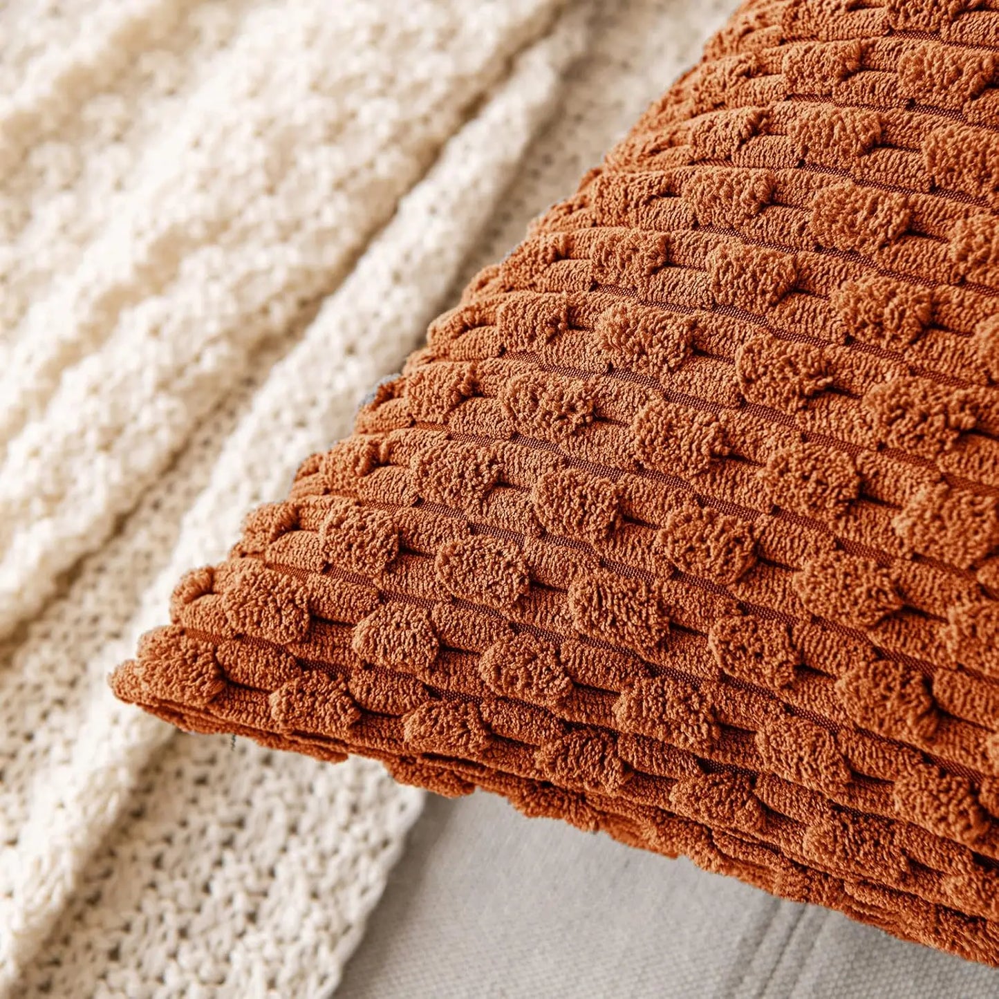 Close-up of a textured brown rust orange fabric against a neutral background