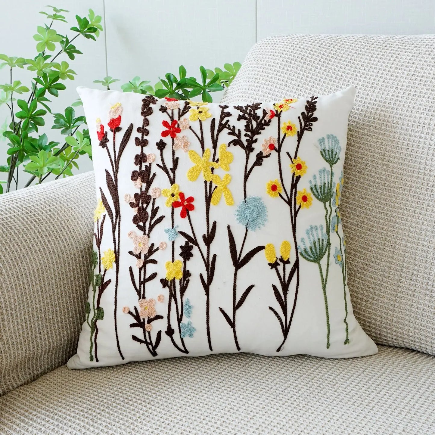 Decorative pillow with floral pattern on a beige couch. Floral embroidered throw pillow cover boho decor