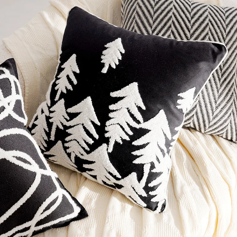Black and white patterned pillows on a beige surface. Boho Holiday decor