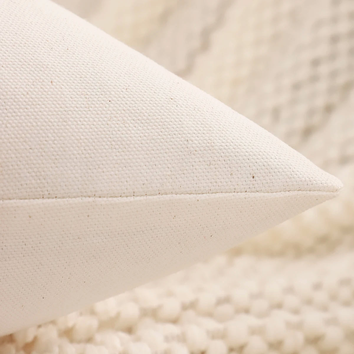Close-up of a textured white pillow on a soft beige surface. Christmas embroidered pillow cover with tufted snowflake and reindeer design in 18x18 inches, festive canvas cushion case for sofa or bed