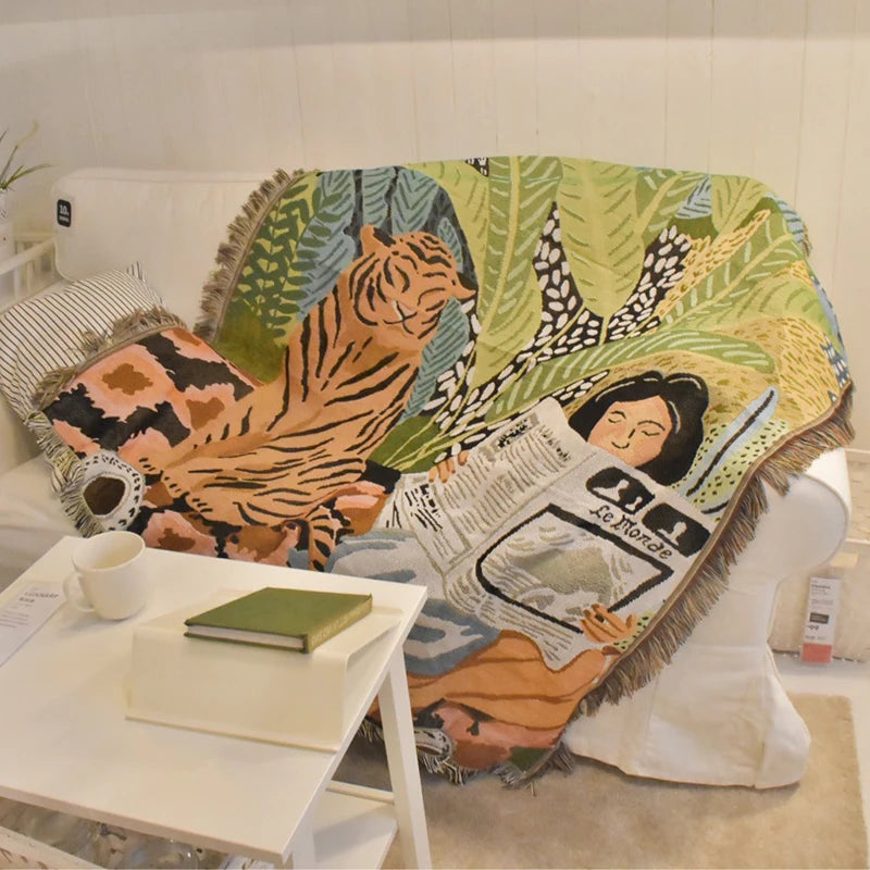 Decorative blanket with a tiger and woman design on a couch. Rainforest tiger geometric throw blanket, abstract woven tapestry for sofa or wall decor, cotton boho blanket for modern home styling.