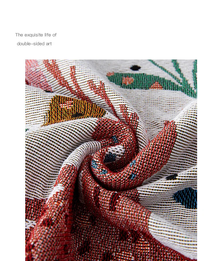 Close-up of intricately patterned fabric with red, white, and blue colors. Deer forest jacquard woven blanket with floral and woodland tapestry design – boho throw for sofa or bed, soft cotton blend decorative bedspread for cozy home décor.