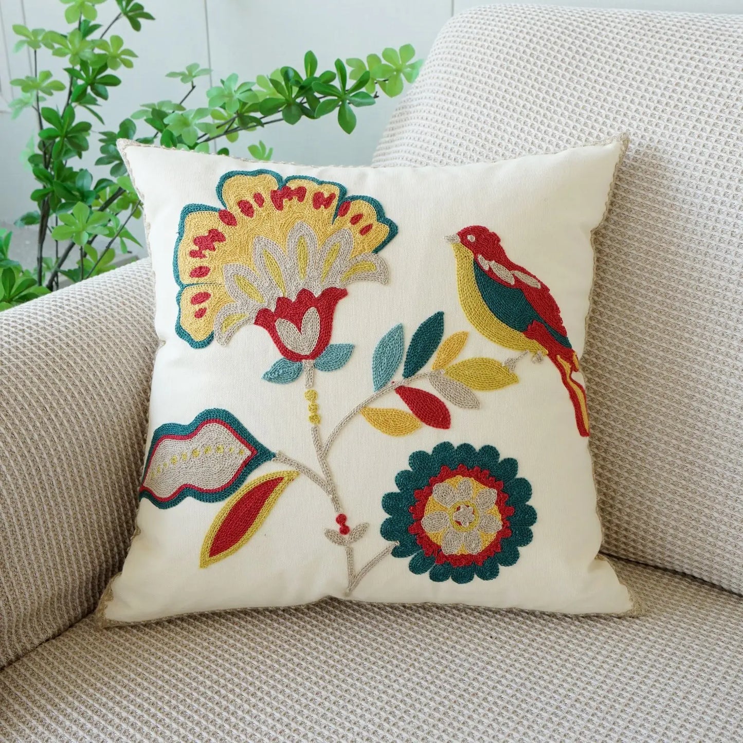 Decorative pillow with floral and bird patterns on a beige couch. Floral embroidered throw pillow cover boho decor
