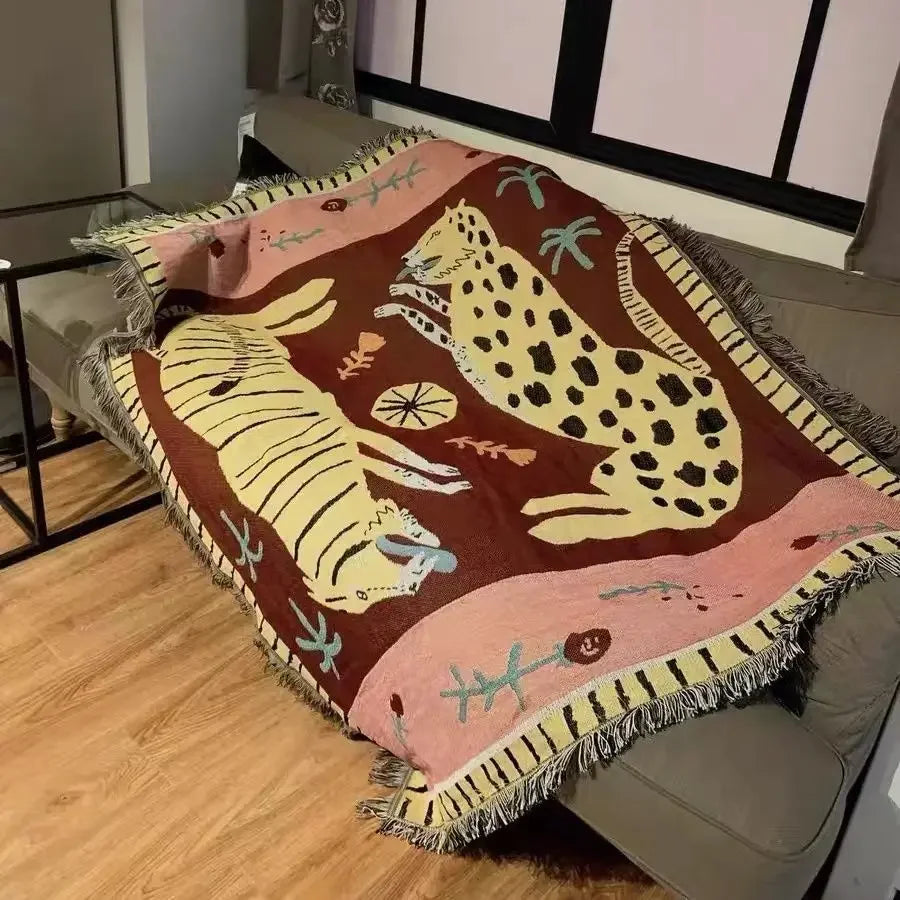 Decorative throw blanket with animal patterns on a couch Animal print bohemian throw blanket with leopards, woven cotton polyester tapestry blanket