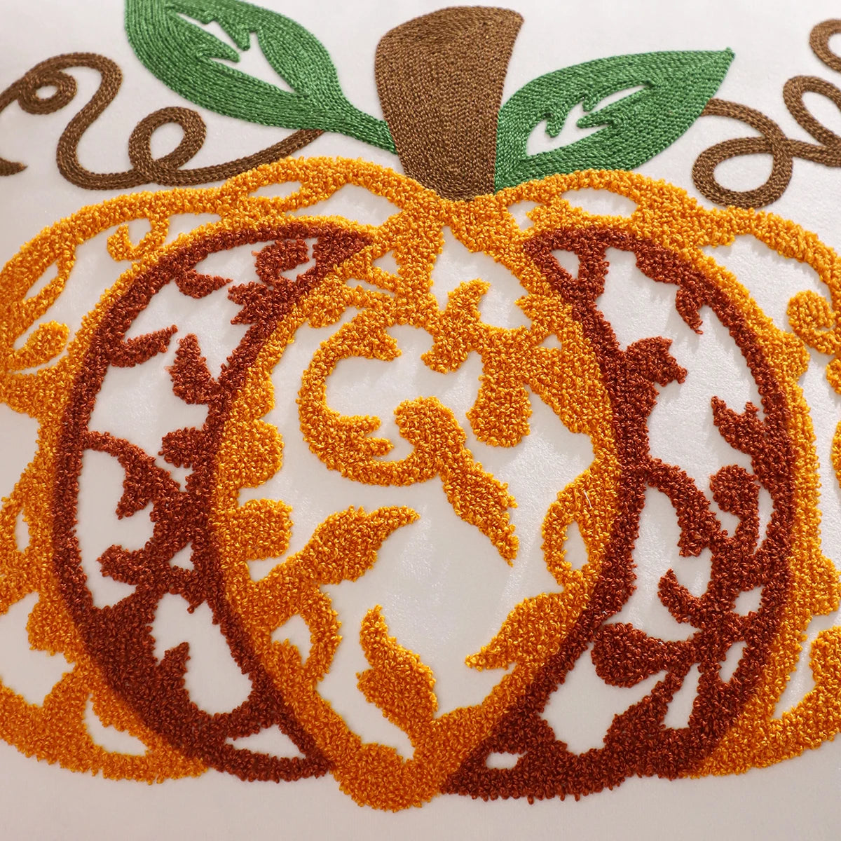 Embroidered pumpkin design on fabric with orange, brown, and green colors. Velvet pillow cover with embroidered pumpkins, sunflowers, and autumn leaves – cozy fall home décor for sofa or living room.