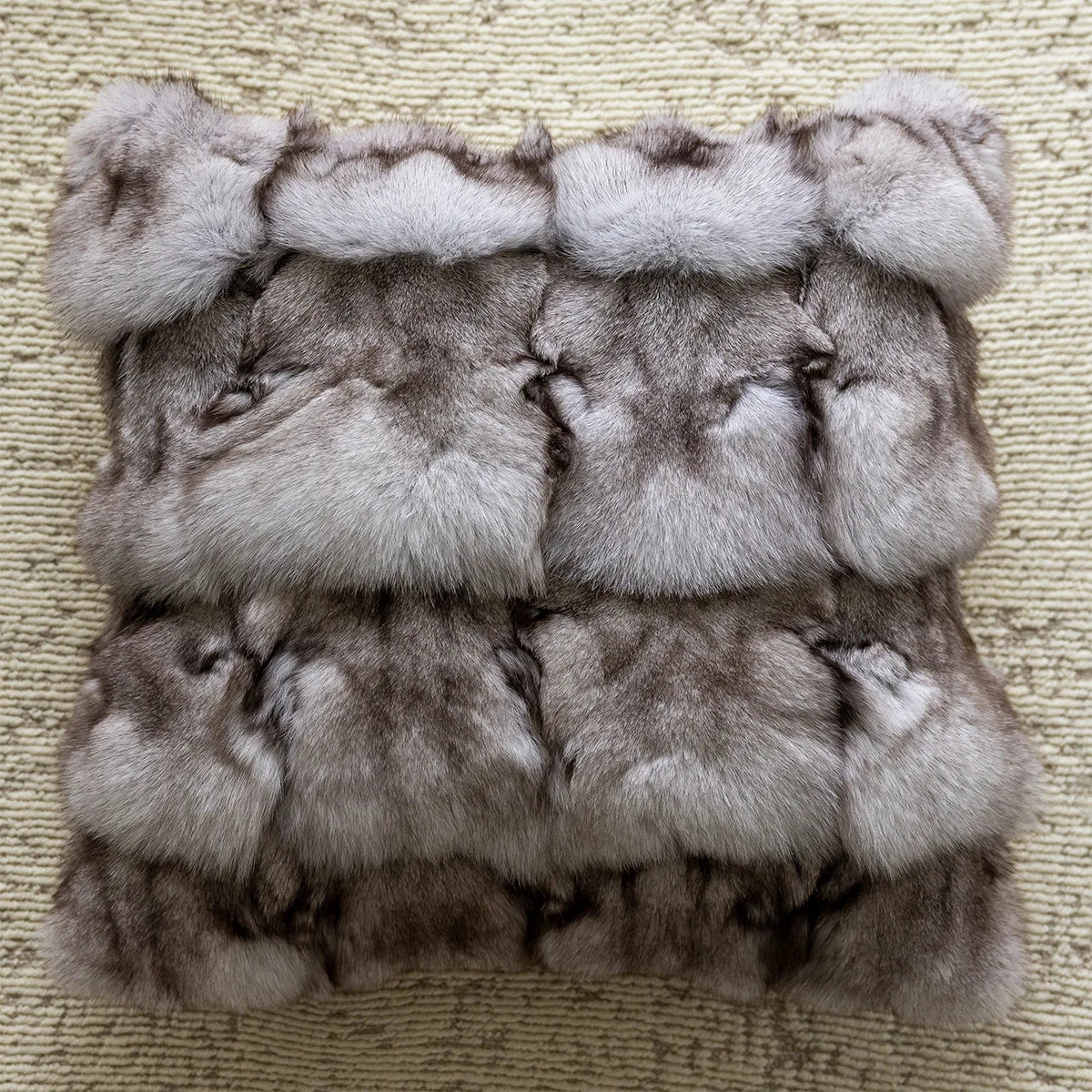 Stack of gray fur items on a textured beige surface. embroidery throw pillow cover in boho modern style