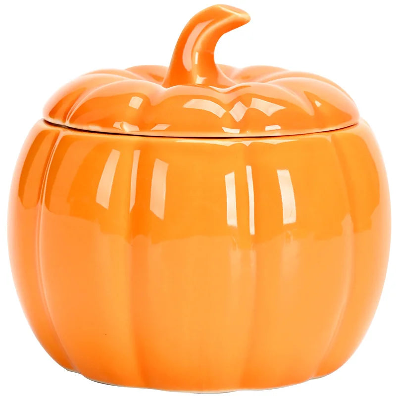 Orange ceramic pumpkin-shaped container on a white background. Ceramic pumpkin candy jar with lid, decorative fall tea jar or wedding gift container for home or halloween holiday decor.