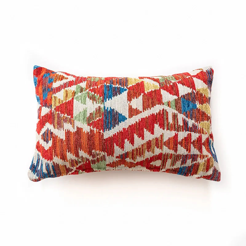 Multicolored geometric patterned pillow on a white background. Bohemian Aztec woven pillow cover, geometric jacquard cushion for sofa, bed, or living room decor in neutral cotton blend fabric.